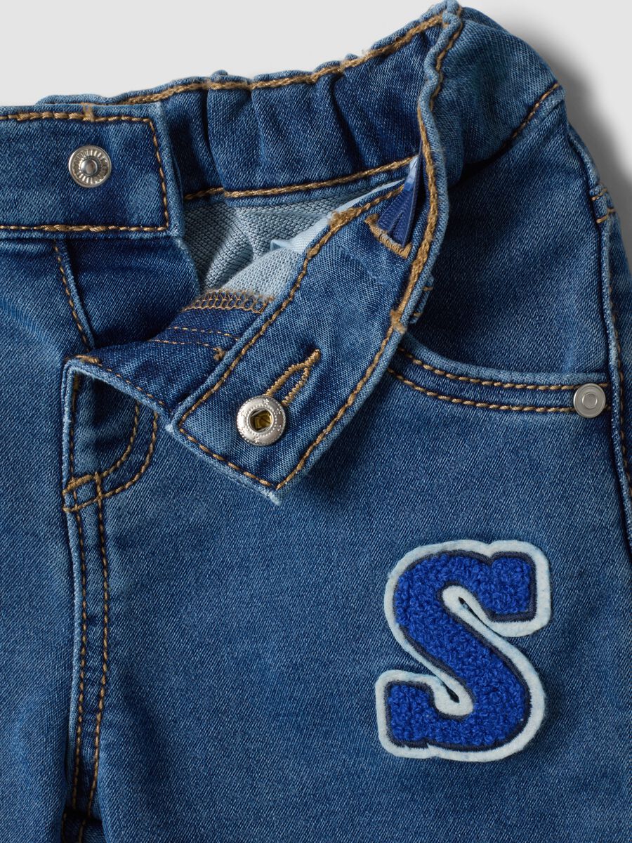 Blue stretch cotton jeans with varsity-style appliqu&eacute;s for baby boy_2
