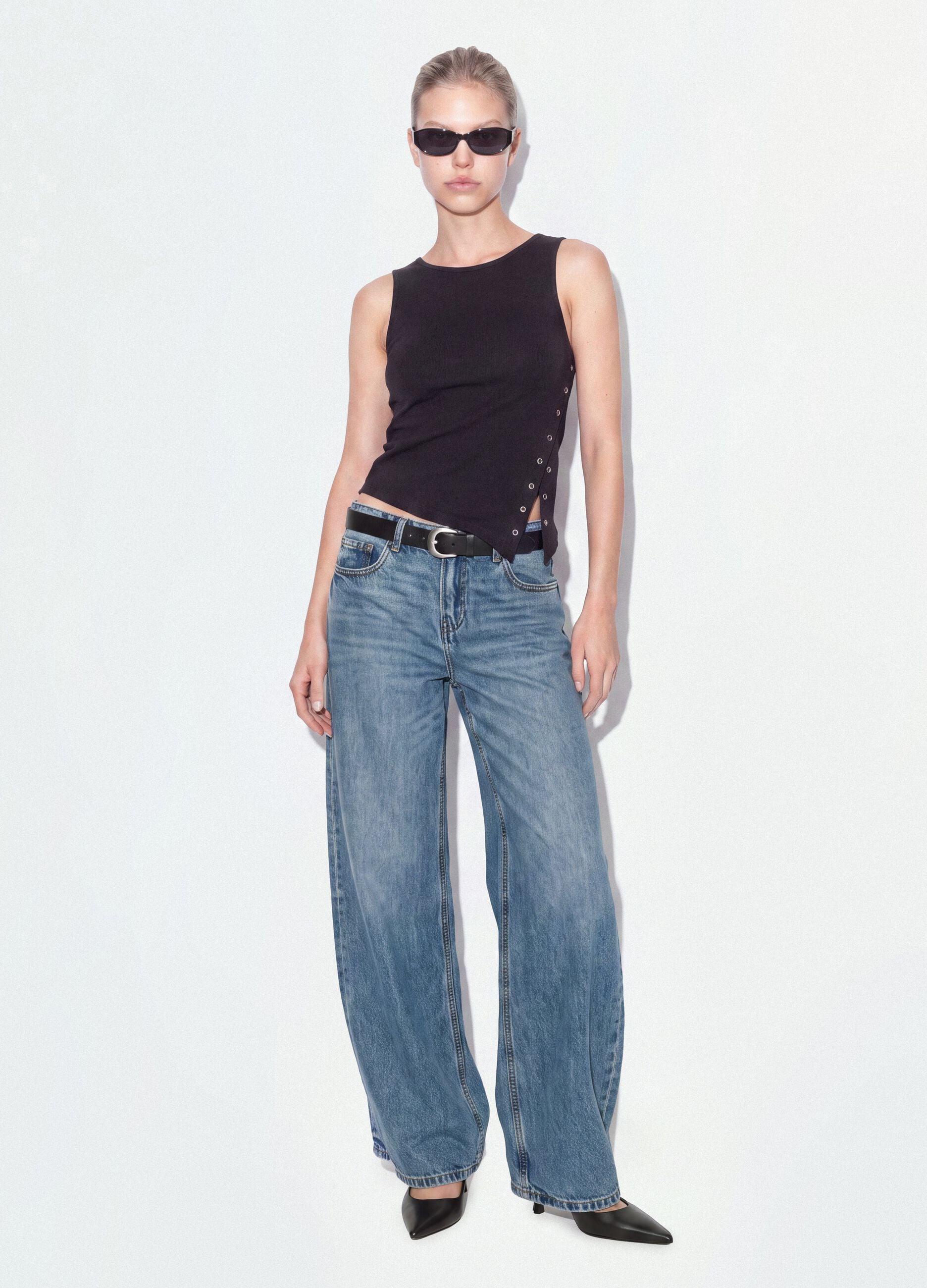 Black stretch cotton top with asymmetric hem and metal eyelets