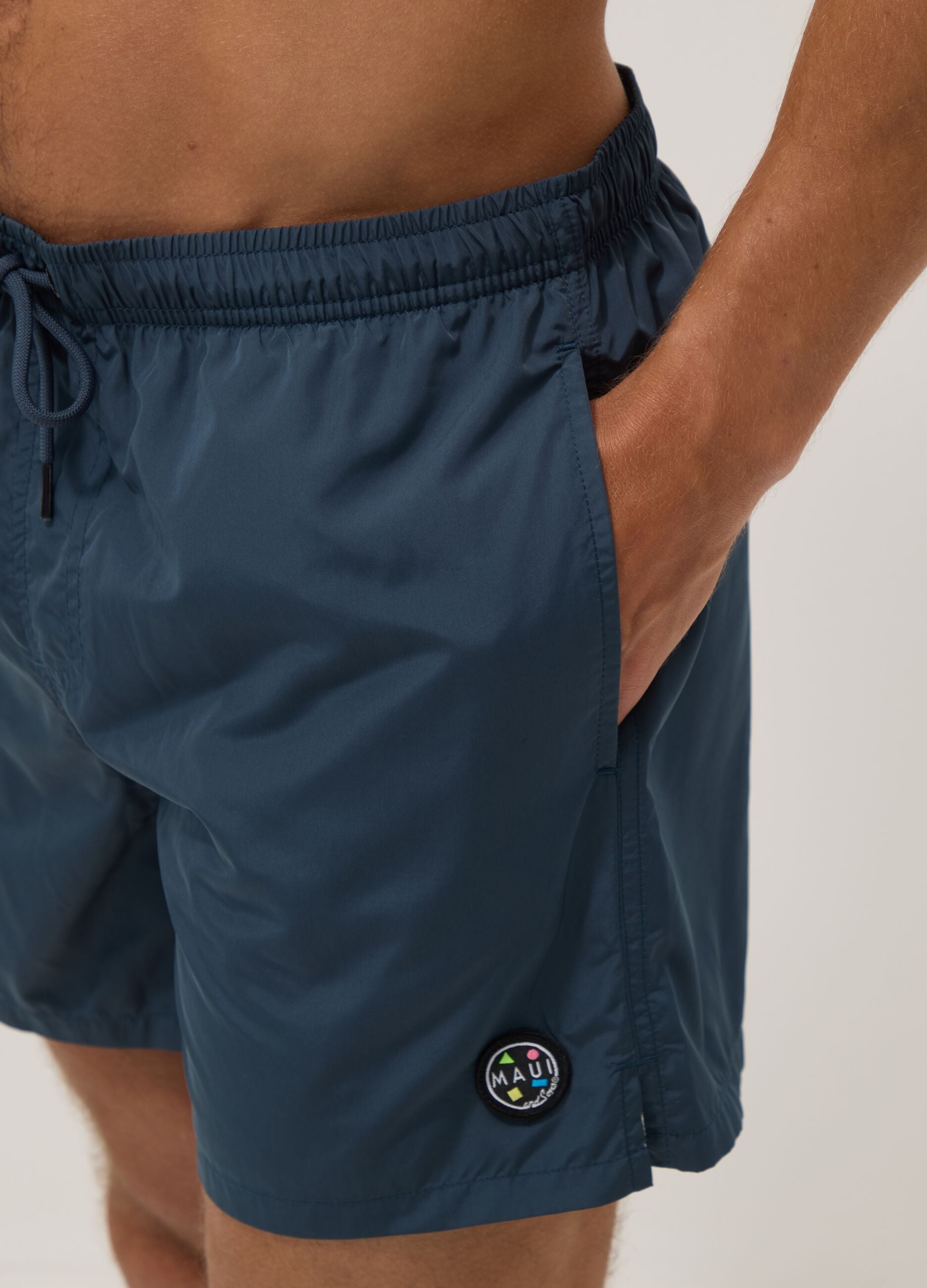 Blue swim shorts with elasticated waistband and drawstring