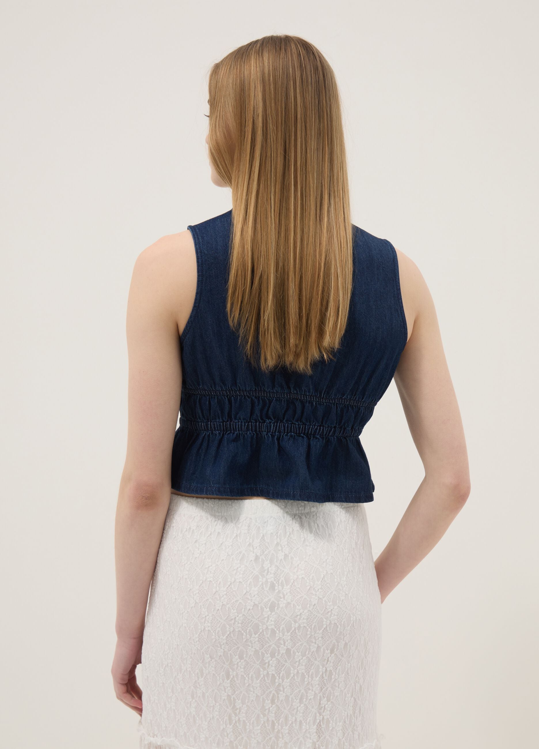 Blue sleeveless denim blouse in pure cotton, slim fit with tie fastening
