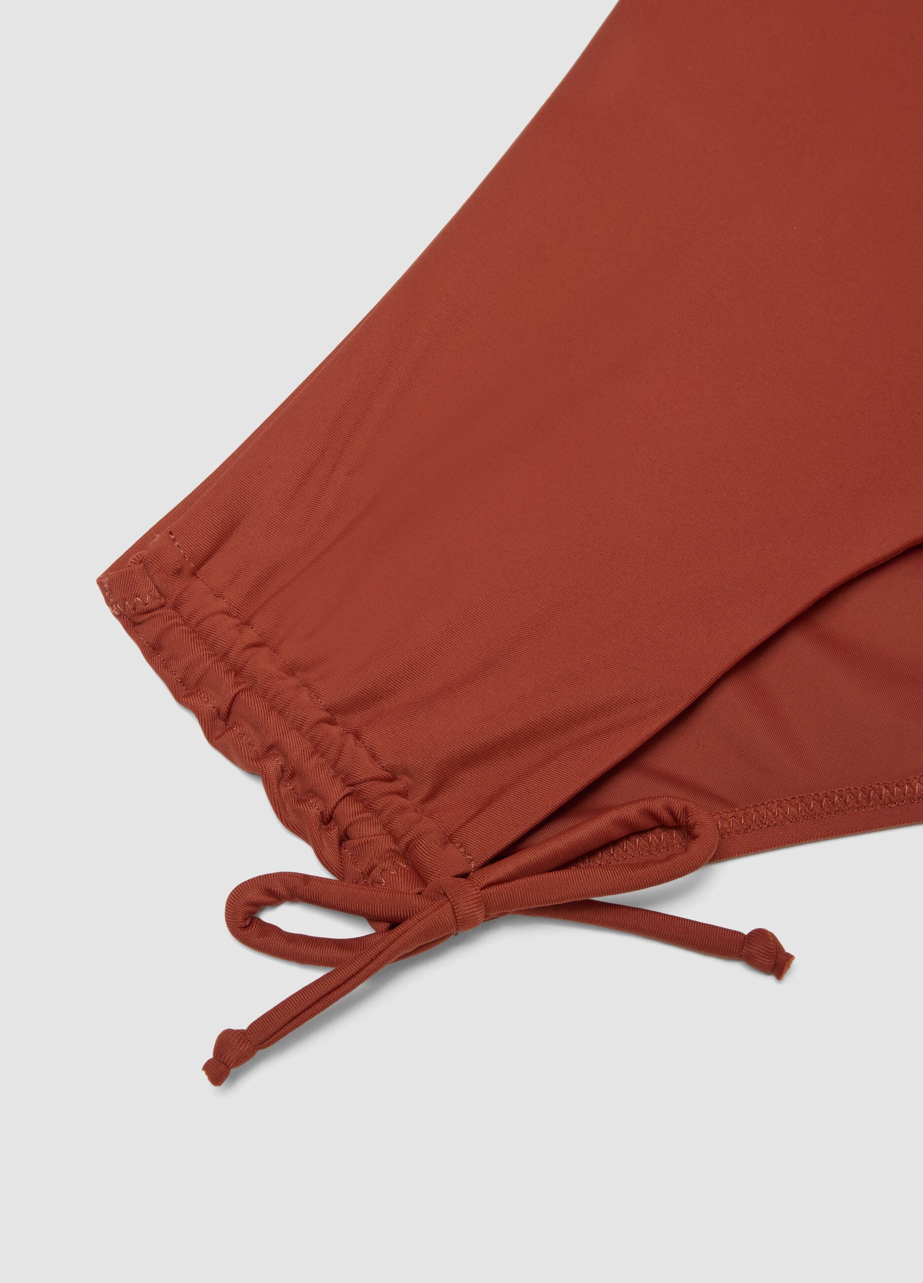 Orange stretch bikini bottoms with ruched side detailing