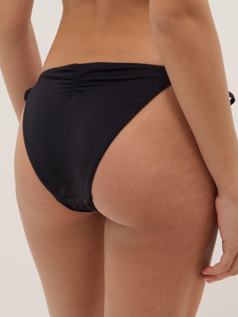 Slip bikini elasticizzato nero con dettagli brillanti_2