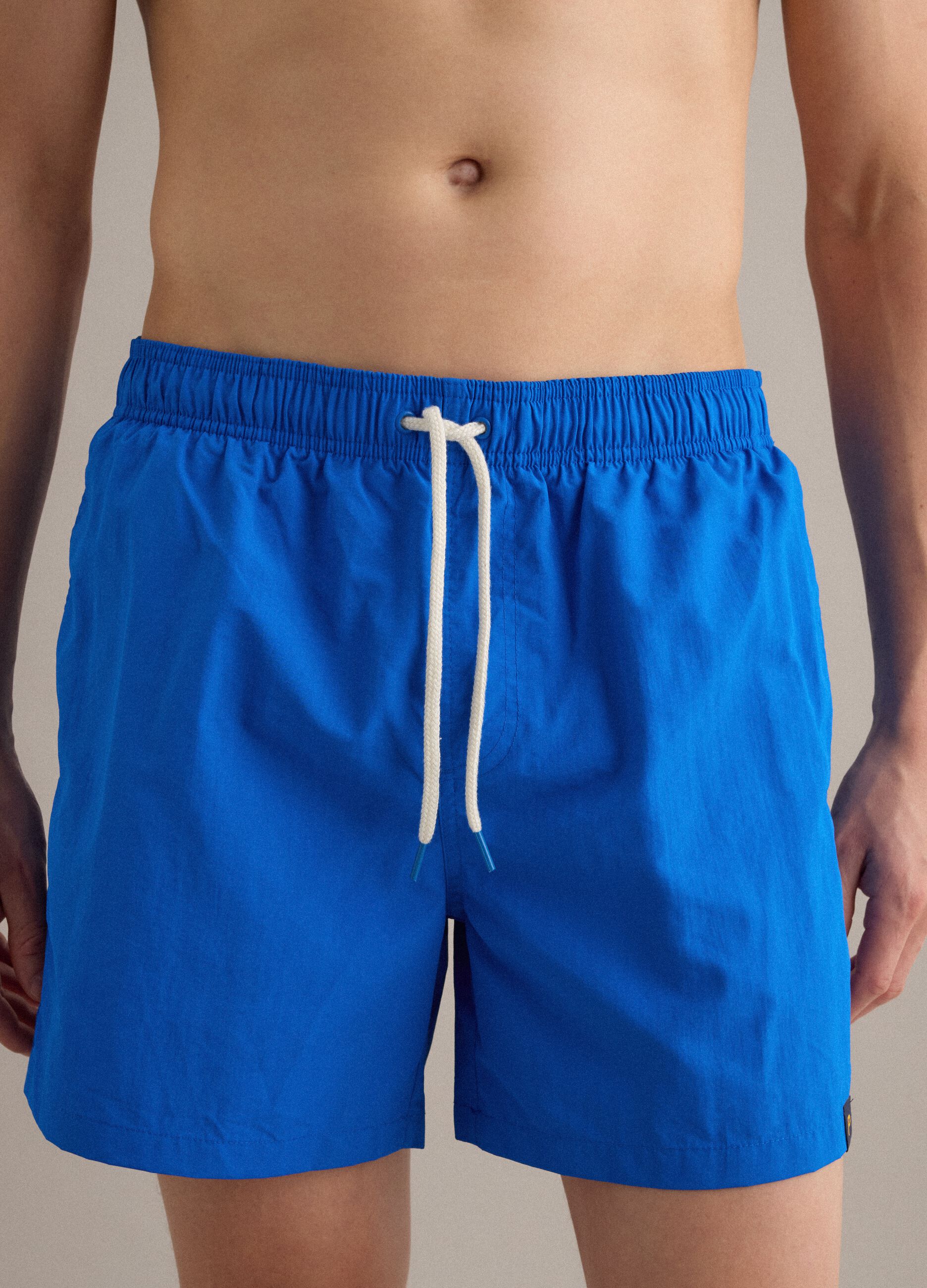 Blue swim shorts with elasticated waist and drawstring