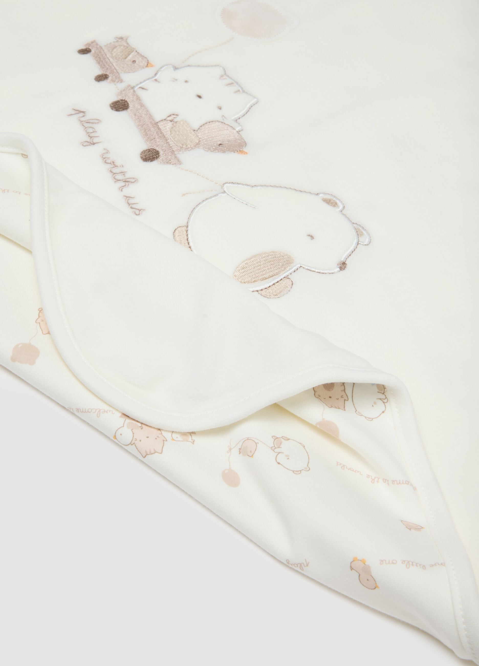 White baby blanket made of cotton blend with decorations