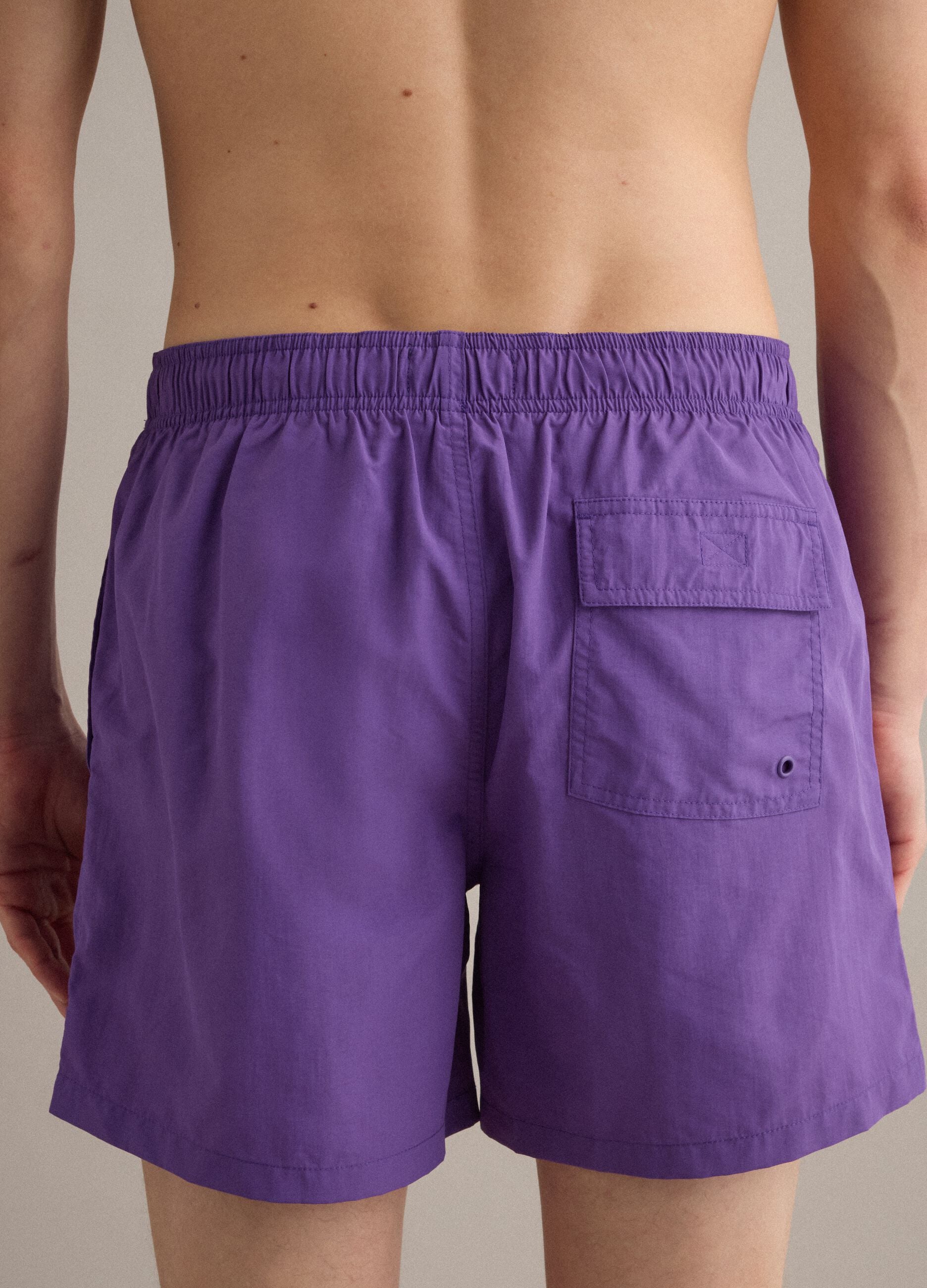 Purple swim shorts with elasticated waistband and drawstring