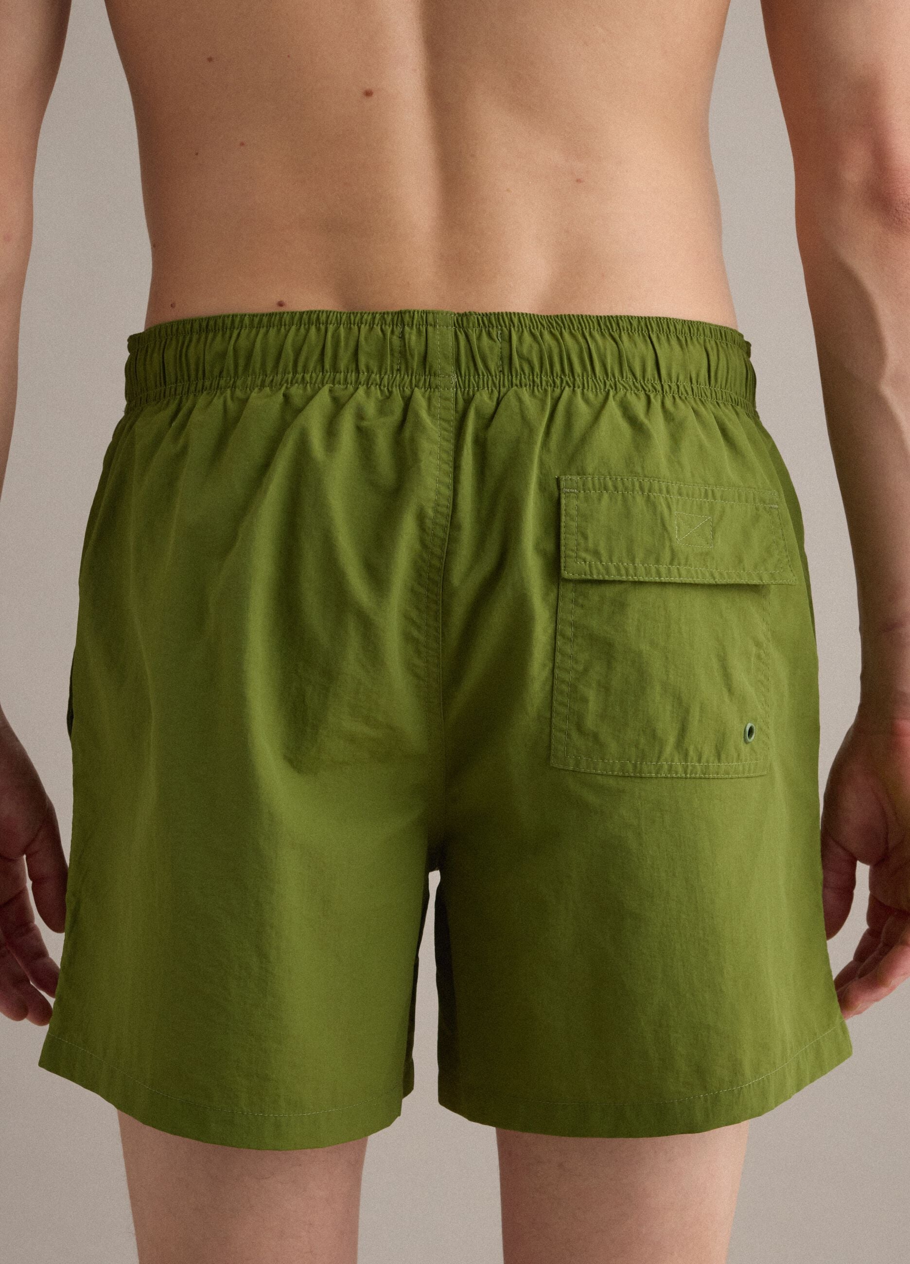 Green swim shorts with elasticated waistband and drawstring