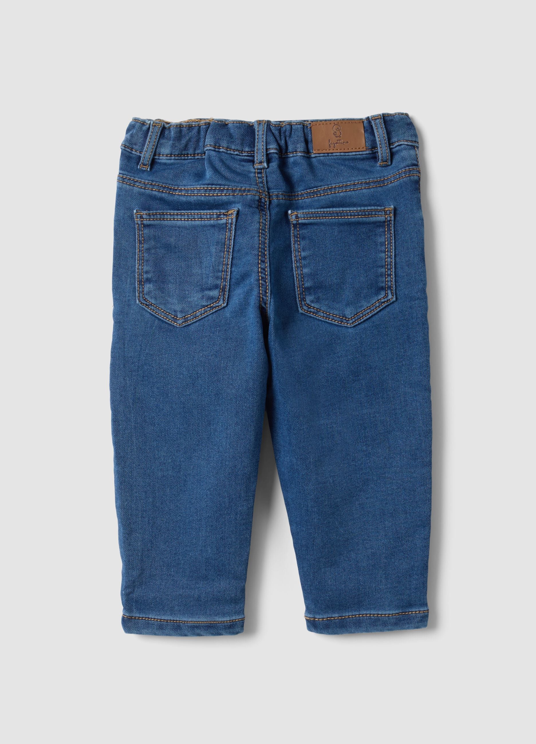Blue stretch cotton jeans with varsity-style appliqu&eacute;s for baby boy