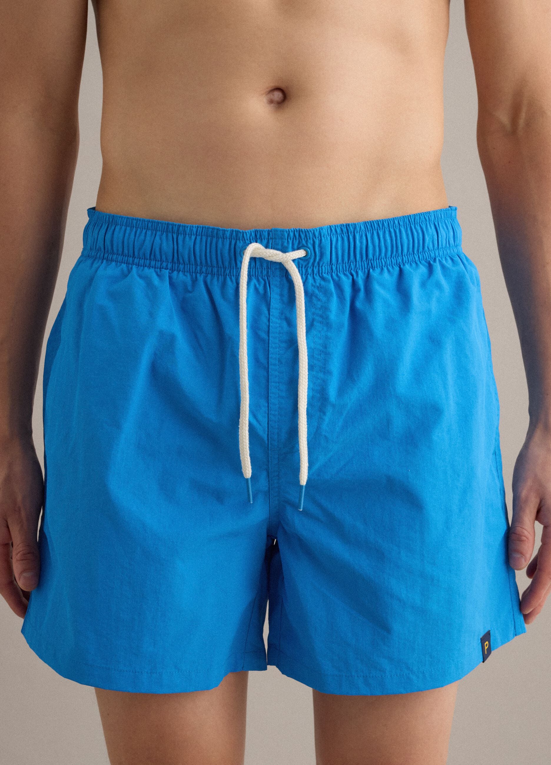 Blue swim shorts with elasticated waistband and contrast drawstring