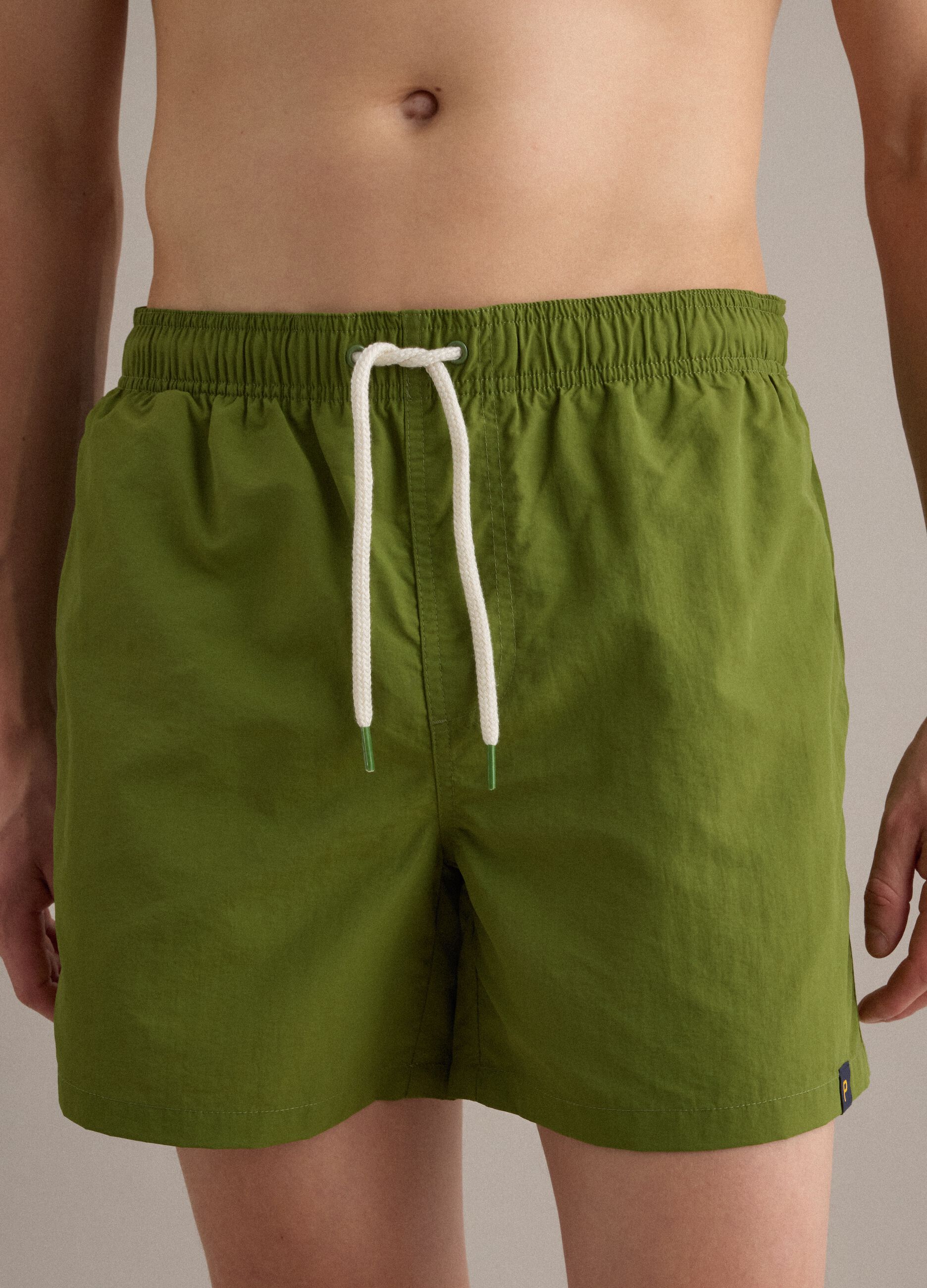 Green swim shorts with elasticated waistband and drawstring