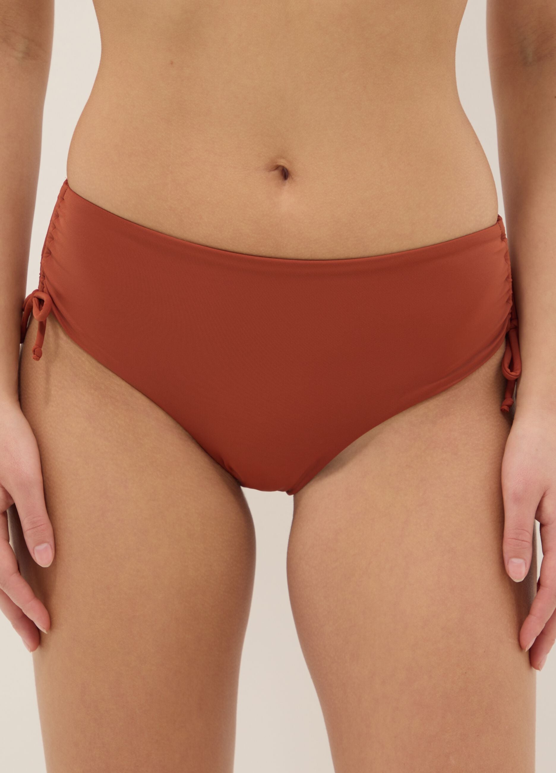 Orange stretch bikini bottoms with ruched side detailing