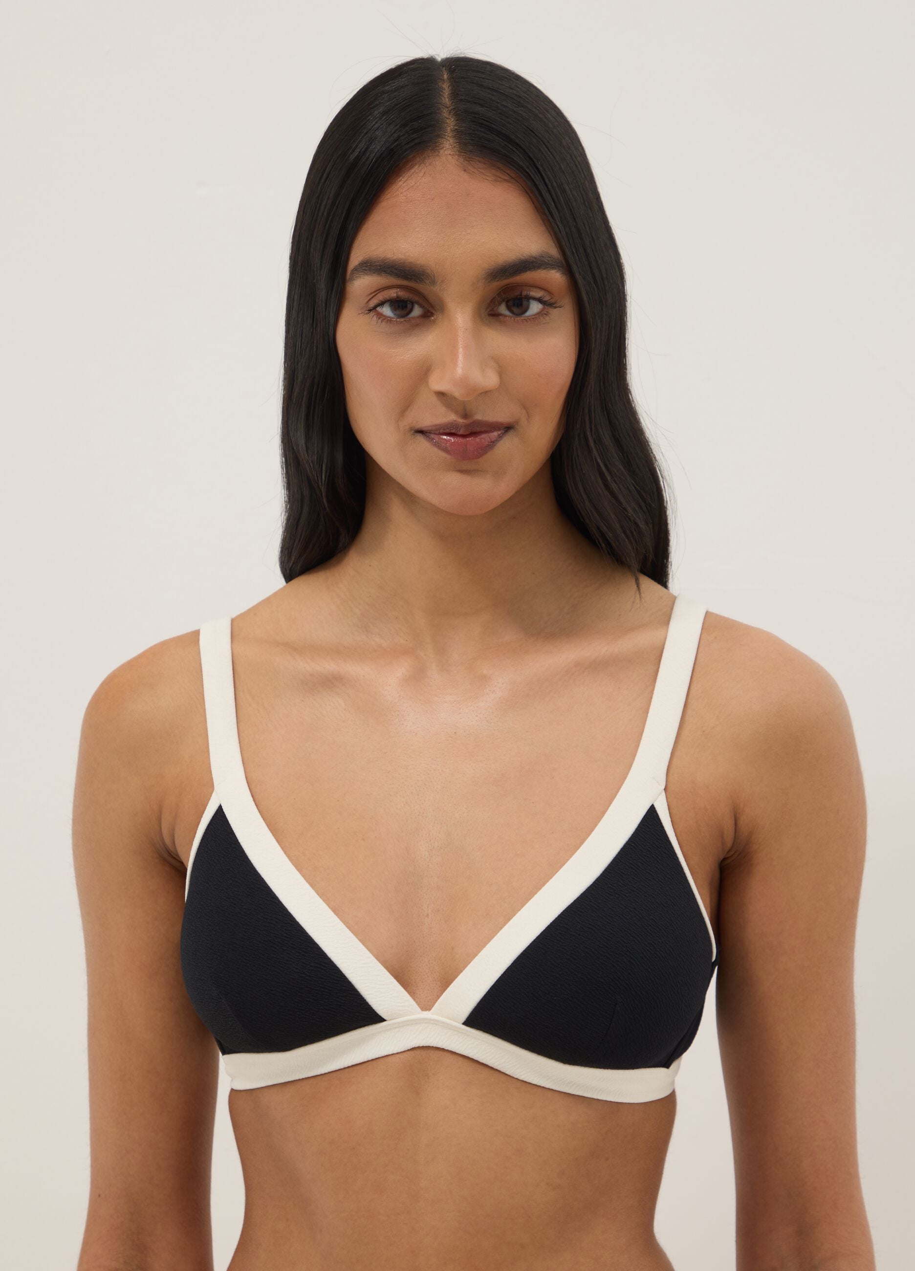 Black stretch-fabric bikini top with white trim and straps