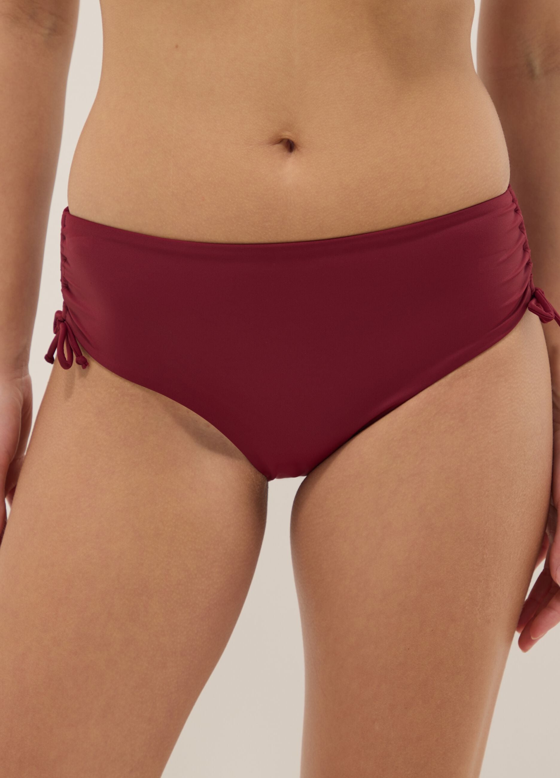 Red stretch bikini bottoms with ruched side detailing
