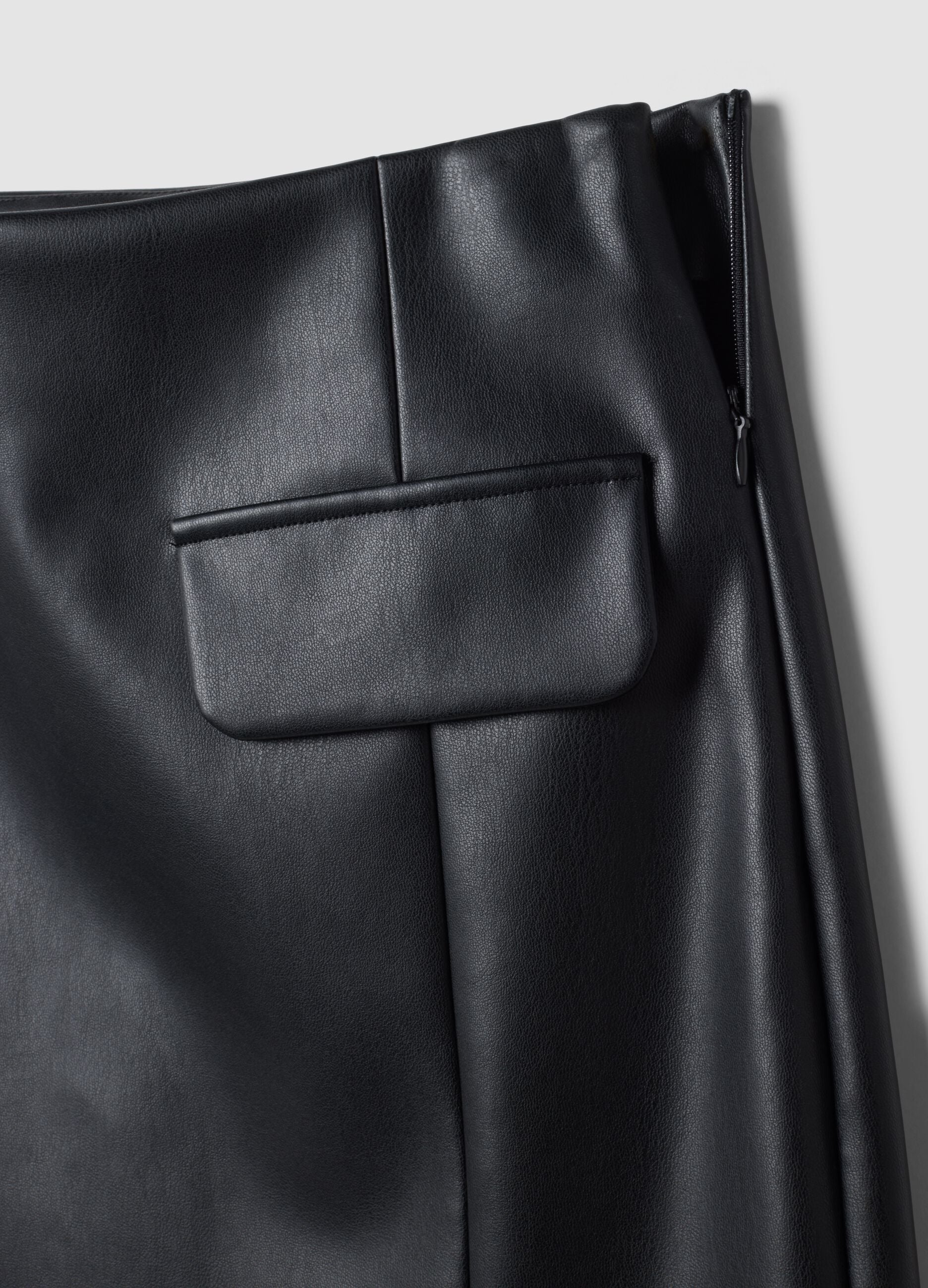 Short black A-line skirt with decorative flap pockets