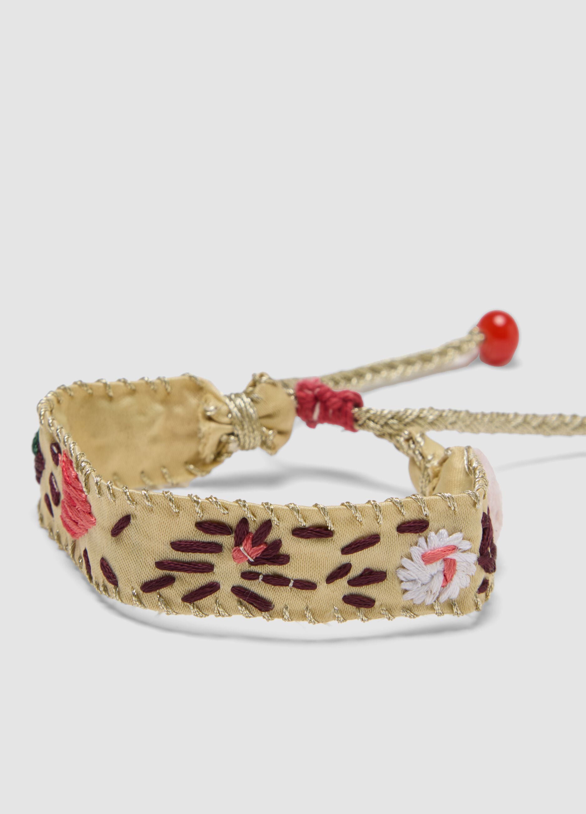 Beige embroidered bracelet with adjustable tie cords