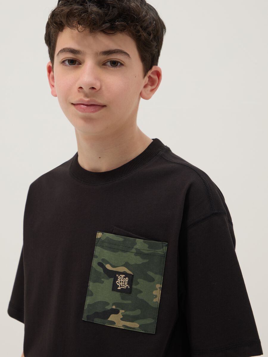 T-shirt in puro cotone nero da ragazzo oversize fit con taschino_1