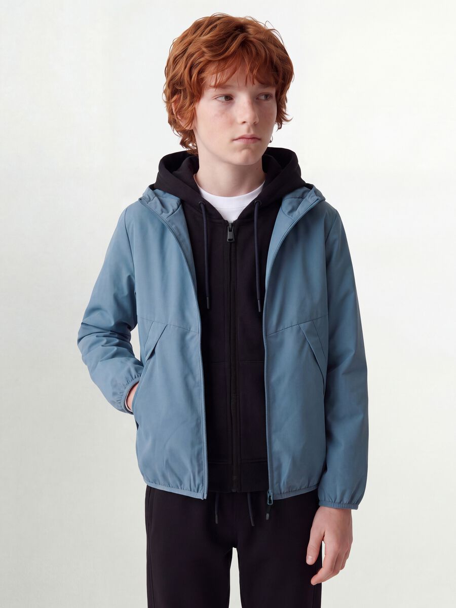 Giacca antipioggia over fit blu con cappuccio e zip per ragazzo_1