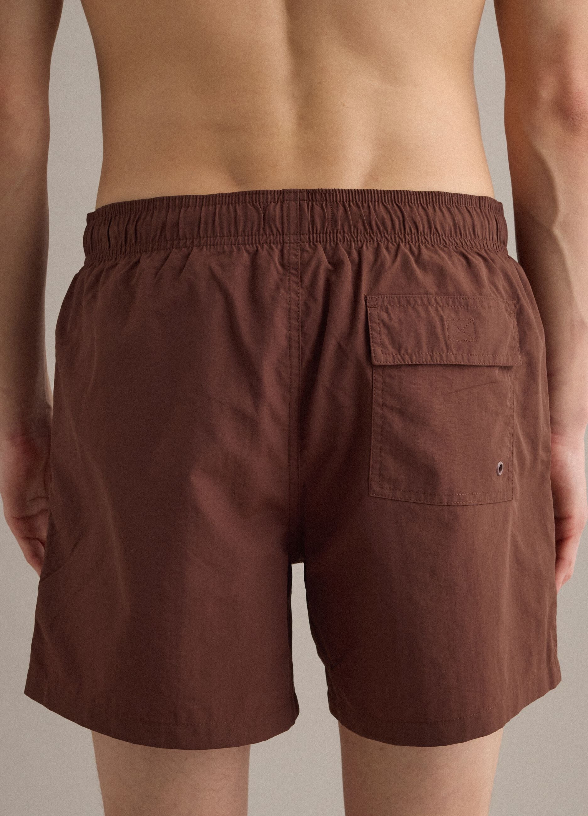 Brown swim shorts with elasticated waistband and drawstring